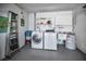 Bright laundry area with modern washer, dryer, sink and hot water heater at 2731 Sherbrooke Ln # D, Palm Harbor, FL 34684