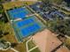 Aerial view of community tennis courts, adjacent parking, and manicured landscaping at 2731 Sherbrooke Ln # D, Palm Harbor, FL 34684