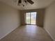 Bedroom with neutral walls, ceiling fan and sliding glass door leading to outdoor space at 3223 Coats Rd, Zephyrhills, FL 33541