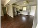 Open kitchen featuring white cabinets, stainless appliances, and dark hardwood floors at 3223 Coats Rd, Zephyrhills, FL 33541