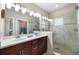 Well-lit bathroom featuring a dual sink vanity, a glass enclosed shower, and modern fixtures at 3226 Nautical S Pl, St Petersburg, FL 33712