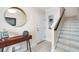 Inviting entryway with console table, mirror, artwork, and staircase leading to upper level at 3226 Nautical S Pl, St Petersburg, FL 33712