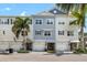 Daytime view of townhome exterior featuring manicured landscaping, private garages, and inviting facade at 3226 Nautical S Pl, St Petersburg, FL 33712