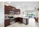 Bright kitchen with stainless steel appliances, dark wood cabinets, and adjacent dining area with water views at 3226 Nautical S Pl, St Petersburg, FL 33712