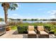 Relaxing patio featuring comfortable seating, grill, lush greenery, and a tranquil lake view to create a serene outdoor space at 3226 Nautical S Pl, St Petersburg, FL 33712