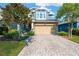 Charming two-story home features stone accents, a well-manicured lawn, and a brick paved driveway leading to a two car garage at 4071 Balcony Breeze Dr, Land O Lakes, FL 34638