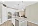 Modern kitchen with stainless steel appliances, a large kitchen island with a marble countertop, and white cabinetry at 4071 Balcony Breeze Dr, Land O Lakes, FL 34638