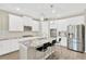 Bright kitchen featuring a large island with granite countertops, stainless steel appliances, and white cabinets at 4071 Balcony Breeze Dr, Land O Lakes, FL 34638