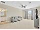 Upstairs living room with a ceiling fan, a comfortable gray sofa, a large window with striped curtains, and a TV set at 4071 Balcony Breeze Dr, Land O Lakes, FL 34638