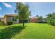 The backyard has a well maintained lawn with shrubbery and tree at 4946 Sapphire Sound Dr, Wimauma, FL 33598
