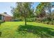 This backyard features a lush green lawn surrounded by mature trees and manicured shrubbery at 4946 Sapphire Sound Dr, Wimauma, FL 33598