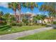 Inviting home with tropical landscaping, vibrant flowers, and a neatly maintained green lawn at 4946 Sapphire Sound Dr, Wimauma, FL 33598