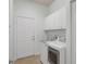 A functional laundry room boasts white cabinets and updated appliances at 4946 Sapphire Sound Dr, Wimauma, FL 33598