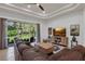 Cozy living room with a large sectional, a flat-screen TV, and a backyard view through large windows at 4946 Sapphire Sound Dr, Wimauma, FL 33598