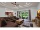 Spacious living room includes a large window, a brown sectional, and an open kitchen view at 4946 Sapphire Sound Dr, Wimauma, FL 33598