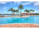 Resort-style pool with lounge chairs, sun umbrellas, and scenic lake views at 4946 Sapphire Sound Dr, Wimauma, FL 33598