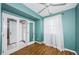 Bedroom with hardwood floors, a teal accent wall, and french doors leading to the ensuite bathroom at 6315 Shoreline Dr # 3305, Madeira Beach, FL 33708