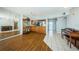 Open-concept living room with wood floors, a decorative hutch, piano, and a view into the adjacent kitchen at 6315 Shoreline Dr # 3305, Madeira Beach, FL 33708