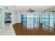 Spacious living room featuring wood floors, ceiling fan, and glass doors to balcony overlooking the water at 6315 Shoreline Dr # 3305, Madeira Beach, FL 33708