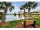 Scenic pond view with palm trees and seating area in a serene, well-manicured community at 6315 Shoreline Dr # 3305, Madeira Beach, FL 33708