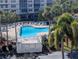 A view of the community pool surrounded by tropical palm trees and lounge chairs at 6315 Shoreline Dr # 3305, Madeira Beach, FL 33708