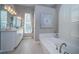 Well-lit bathroom featuring double sinks, a soaking tub, and modern fixtures at 9101 Highland Ridge Way, Tampa, FL 33647