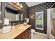 Stylish bathroom with elegant vanity, decorative mirror, and patterned wallpaper at 9101 Highland Ridge Way, Tampa, FL 33647