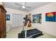 Bright bedroom with a treadmill, a large window, and double closet doors at 9101 Highland Ridge Way, Tampa, FL 33647