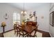 Elegant dining room with hardwood floors, a stylish chandelier, and a large window with shutter blinds at 9101 Highland Ridge Way, Tampa, FL 33647