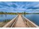 Wooden dock extending into a serene lake, perfect for fishing and enjoying waterfront views at 9101 Highland Ridge Way, Tampa, FL 33647
