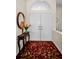 Inviting entryway featuring double doors, a decorative rug, and a table with a mirror, creating a warm welcome at 9101 Highland Ridge Way, Tampa, FL 33647