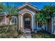 Inviting front door with an arched entryway and beautiful landscaping at 9101 Highland Ridge Way, Tampa, FL 33647