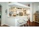 Open-concept kitchen with white cabinets, hardwood floors, and a breakfast bar, perfect for casual dining at 9101 Highland Ridge Way, Tampa, FL 33647