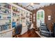 Home office with custom bookshelves, dual workstations, hardwood flooring, and natural light at 9101 Highland Ridge Way, Tampa, FL 33647