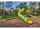 Community playground with a green and yellow slide, tower, and climbing structures for outdoor fun at 9101 Highland Ridge Way, Tampa, FL 33647