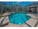 Screened-in pool with brick trim and an attached spa with outdoor seating at 9101 Highland Ridge Way, Tampa, FL 33647