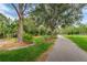 Scenic walking path with lush greenery and mature trees, complemented by a park bench at 9101 Highland Ridge Way, Tampa, FL 33647