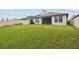 Large backyard with lush green grass, white fencing, and a screened-in patio for outdoor enjoyment at 9645 Little Bluestem Dr, Land O Lakes, FL 34637
