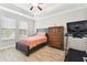 View of the bedroom with a large window, hardwood floors, a dresser, and a treadmill at 9645 Little Bluestem Dr, Land O Lakes, FL 34637