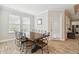 Dining room with a large wooden table, modern chairs, and natural light from multiple windows at 9645 Little Bluestem Dr, Land O Lakes, FL 34637