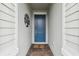Inviting entryway showcasing a blue front door, brick pathway, and decorative welcome sign at 9645 Little Bluestem Dr, Land O Lakes, FL 34637
