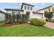 Charming home with manicured front yard, lush landscaping, and appealing architectural details at 9645 Little Bluestem Dr, Land O Lakes, FL 34637