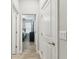 Hallway leading to bedroom with wood-look tile flooring and white doors at 9645 Little Bluestem Dr, Land O Lakes, FL 34637