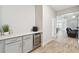 Hallway with beverage center including gray cabinets, quartz countertop and wine cooler at 9645 Little Bluestem Dr, Land O Lakes, FL 34637