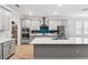 Modern kitchen with a large island, stainless steel appliances, and stylish gray cabinetry at 9645 Little Bluestem Dr, Land O Lakes, FL 34637