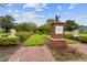 The entrance to Magnolia Park features manicured landscaping, brick pavers, and a brick column with a statue at 9645 Little Bluestem Dr, Land O Lakes, FL 34637