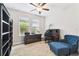 Comfortable home office with a blue chair, ottoman, dark wood furniture, and ample natural light at 9645 Little Bluestem Dr, Land O Lakes, FL 34637