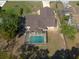 See the aerial view featuring a screened in pool in a backyard with mature trees providing plenty of shade at 11304 Sedgefield Ave, Spring Hill, FL 34608