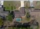 Top-down aerial view showing this home's sparkling pool and verdant backyard in a quiet neighborhood at 11304 Sedgefield Ave, Spring Hill, FL 34608