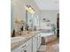 Bright bathroom featuring a double vanity, granite countertops and a soaking tub at 15664 Starling Water Dr, Lithia, FL 33547